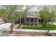 Charming single-story home with a stone facade, inviting porch, lush landscaping, and a well-manicured lawn at 20421 W Legend Trl, Buckeye, AZ 85396