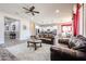 Bright living room featuring tile flooring, leather sofas, a ceiling fan, and views of the kitchen at 20421 W Legend Trl, Buckeye, AZ 85396