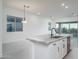 Modern kitchen island with stainless steel appliances, white cabinetry, and an eat-in kitchen area at 20961 W Pasadena Ave, Buckeye, AZ 85396