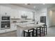 Modern kitchen with white cabinetry, stainless steel appliances, and a large island and seating at 20961 W Pasadena Ave, Buckeye, AZ 85396