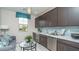 Stylish kitchenette with blue backsplash, stainless steel appliances, and a comfortable seating area at 20961 W Pasadena Ave, Buckeye, AZ 85396