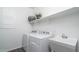 This modern laundry room includes new appliances, shelving, and a wash sink at 20961 W Pasadena Ave, Buckeye, AZ 85396