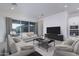 Living room featuring sofas, a modern television console, and access to an outdoor patio at 20961 W Pasadena Ave, Buckeye, AZ 85396