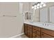 Bathroom features double sinks with wood cabinets, white counter and a large mirror at 211 W New Dawn Dr, Chandler, AZ 85248