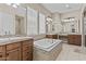 Luxurious bathroom with a soaking tub, double sinks, vanity, and decorative tile accents at 211 W New Dawn Dr, Chandler, AZ 85248