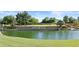 Fulton Ranch entrance showcases a serene lake, green landscaping, and stone signage under a blue sky at 211 W New Dawn Dr, Chandler, AZ 85248