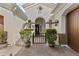 Covered entry courtyard with iron gate and mature potted plants create inviting curb appeal at 211 W New Dawn Dr, Chandler, AZ 85248