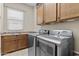 Convenient laundry room with stainless steel washer and dryer and upper cabinets at 211 W New Dawn Dr, Chandler, AZ 85248