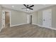 Spacious primary bedroom with walk-in closet, en-suite bathroom, ceiling fan, and wood-look flooring at 2123 E Radcliffe Dr, Tempe, AZ 85283