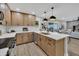 Open-concept kitchen features wood cabinets, an island, stainless steel appliances, and flows into the living and dining area at 2123 E Radcliffe Dr, Tempe, AZ 85283