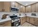 Modern kitchen features wood cabinets, white countertops, stainless steel appliances, and tiled backsplash at 2123 E Radcliffe Dr, Tempe, AZ 85283