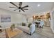 Bright living area open to the updated kitchen, featuring a ceiling fan and wood-look flooring at 2123 E Radcliffe Dr, Tempe, AZ 85283