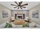 Staged living room area showcasing brick fireplace, ceiling fan, wood floors, and contemporary décor at 2123 E Radcliffe Dr, Tempe, AZ 85283