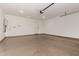 A spacious three car garage with neutral painted walls and bare concrete flooring at 22568 E Rosa Rd, Queen Creek, AZ 85142