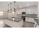 Modern kitchen with white cabinets, stainless appliances, mosaic backsplash and a granite island at 22568 E Rosa Rd, Queen Creek, AZ 85142