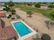 Aerial view of a backyard pool, desert landscaping and a golf course in the distance at 2395 E Hancock Trl, Casa Grande, AZ 85194