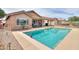 Inviting backyard with a sparkling pool, covered patio, and serene desert landscaping at 2395 E Hancock Trl, Casa Grande, AZ 85194