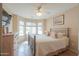 Bright bedroom with a ceiling fan, large windows, neutral tones, and ample natural light at 2395 E Hancock Trl, Casa Grande, AZ 85194