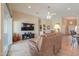 Open-concept living room with a vaulted ceiling, tile flooring, and a brown leather sofa with a TV at 2395 E Hancock Trl, Casa Grande, AZ 85194