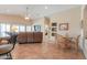 Spacious living room with a vaulted ceiling, tile flooring, and a cozy seating area with a brown leather sofa at 2395 E Hancock Trl, Casa Grande, AZ 85194