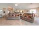 Large living room boasting matching brown leather sofas, tile floors, and a vaulted ceiling at 2395 E Hancock Trl, Casa Grande, AZ 85194