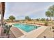 Sparkling pool surrounded by low-maintenance desert landscaping and beautiful green space beyond at 2395 E Hancock Trl, Casa Grande, AZ 85194