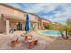Serene backyard with a sparkling pool, patio, outdoor seating, and lush desert landscape, perfect for relaxing at 28136 N 90Th Ln, Peoria, AZ 85383