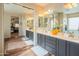 Elegant bathroom with double sinks, vanity, framed mirrors, and wood flooring providing a spa-like experience at 28136 N 90Th Ln, Peoria, AZ 85383