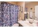 Bathroom featuring a floral shower curtain, decorative wall sconces, and a vanity with a large mirror at 28136 N 90Th Ln, Peoria, AZ 85383