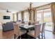 Elegant dining room featuring a chandelier and view of the outdoor pool through sliding glass doors at 28136 N 90Th Ln, Peoria, AZ 85383