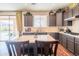Open kitchen featuring gray cabinets, stainless appliances, stone countertops, and a center island with chairs at 28136 N 90Th Ln, Peoria, AZ 85383
