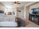 Spacious primary bedroom with a dark wood bed set, a TV stand with fireplace and carpet floors at 28136 N 90Th Ln, Peoria, AZ 85383