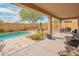 Covered patio with wicker seating and BBQ with backyard pool view and table at 28136 N 90Th Ln, Peoria, AZ 85383