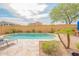 Backyard pool with sun chairs, desert landscaping and patio table at 28136 N 90Th Ln, Peoria, AZ 85383