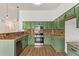 Updated kitchen features stainless steel appliances, granite countertops, and green cabinetry at 40427 N Orkney Way, San Tan Valley, AZ 85140