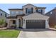 Charming two-story home boasts a well-manicured lawn and a welcoming stone-accented porch at 4771 E Meadow Land Dr, San Tan Valley, AZ 85140