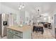 Kitchen island with overhead lighting, stainless fridge, and views to dining/living rooms at 4771 E Meadow Land Dr, San Tan Valley, AZ 85140