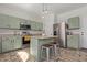 Bright kitchen with green cabinets, center island with seating, and stainless steel appliances at 4771 E Meadow Land Dr, San Tan Valley, AZ 85140