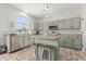 Kitchen with updated green cabinets, stainless steel appliances, and a breakfast bar at 4771 E Meadow Land Dr, San Tan Valley, AZ 85140