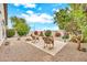 Serene backyard featuring desert landscaping, mature trees, and a charming seating area with rocking chairs at 660 W Twin Peaks Pkwy, San Tan Valley, AZ 85143