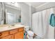 Well-lit bathroom features a single sink vanity and a shower with a decorative shower curtain at 660 W Twin Peaks Pkwy, San Tan Valley, AZ 85143