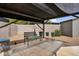 Seating area on patio, shaded by a canopy, with view of brick wall and gravel landscaping at 701 S 92Nd St, Mesa, AZ 85208