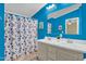 Bright blue bathroom features a double sink vanity, shower-tub combo, and ample lighting at 701 S 92Nd St, Mesa, AZ 85208