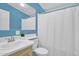 This bright bathroom features blue walls and a white shower curtain at 701 S 92Nd St, Mesa, AZ 85208