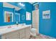 Bright blue bathroom features a double sink vanity, shower-tub combo, and storage at 701 S 92Nd St, Mesa, AZ 85208