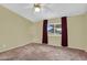 Neutral primary bedroom features ceiling fan, plush carpeting, and sunlit window views at 701 S 92Nd St, Mesa, AZ 85208