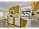 Bright kitchen showcasing yellow cabinets, a white range and dishwasher, and a view of the outdoors from the window over the sink at 701 S 92Nd St, Mesa, AZ 85208