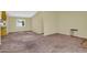 Open living area with neutral carpeting, bright window and a glimpse into the kitchen, creating a versatile living space at 701 S 92Nd St, Mesa, AZ 85208