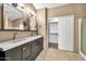 Elegant bathroom with dual sinks, quartz counters, and closet at 7214 W Crest Ln, Glendale, AZ 85310