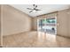 A neutral-toned bedroom with a ceiling fan, tile flooring, and a sliding glass door to the patio at 7214 W Crest Ln, Glendale, AZ 85310